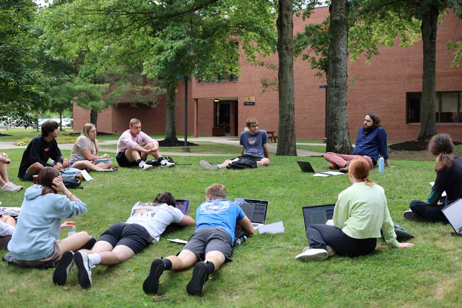 Students sitting in the quad together for a class