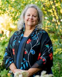 Photo of Robin Wall Kimmerer with trees in the background