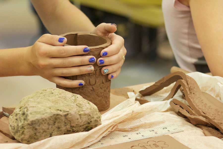 Hands forming a ceramic piece