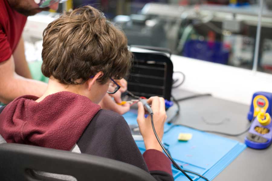 A kid working with soldering wires
