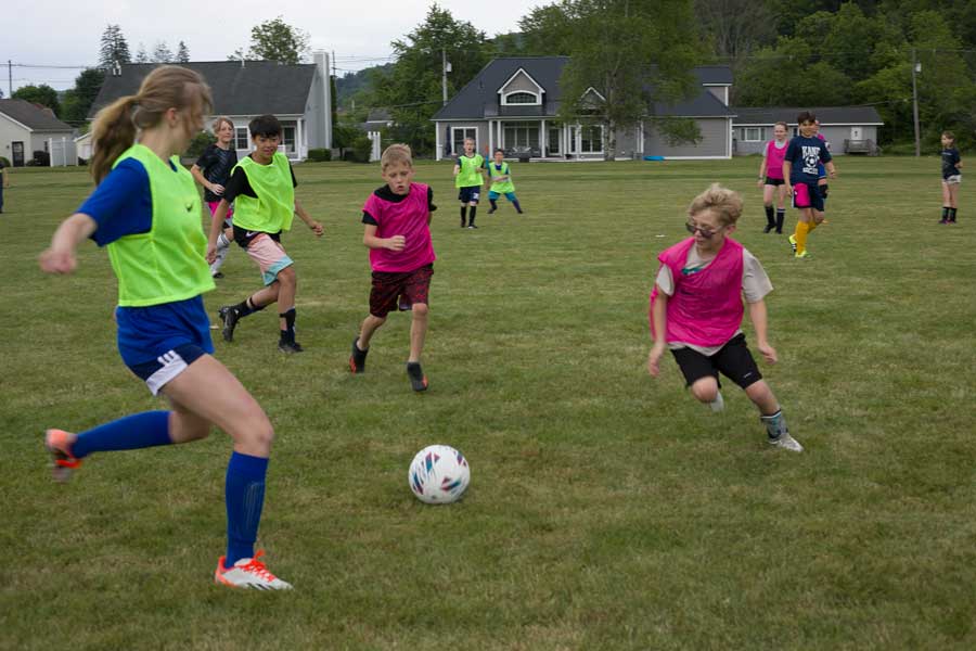 children playing soccer during a camp