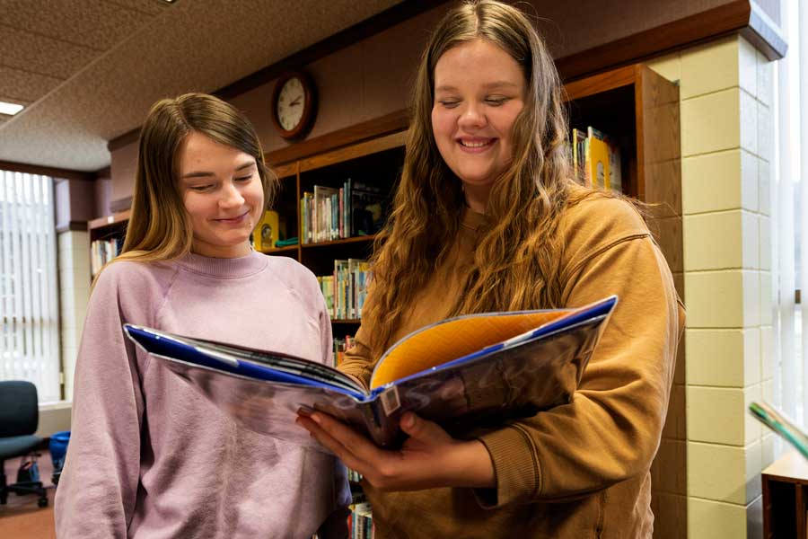 Education students in the library with a children's book