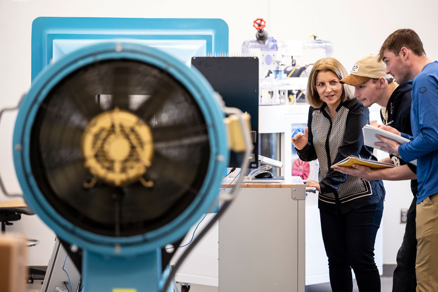 Professor and students observing at the wind tunnel