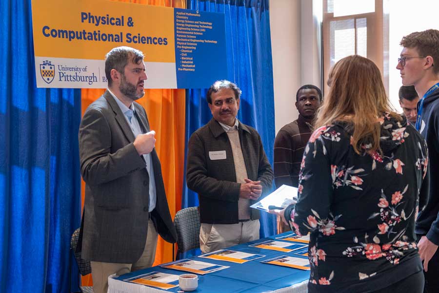 students visiting a table during open house