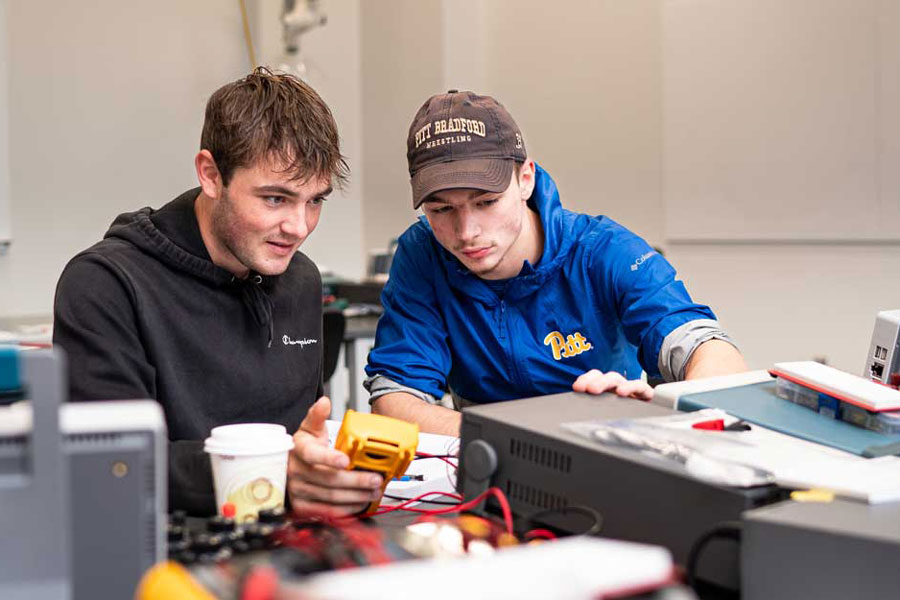 Two students looking at a digital multimeter