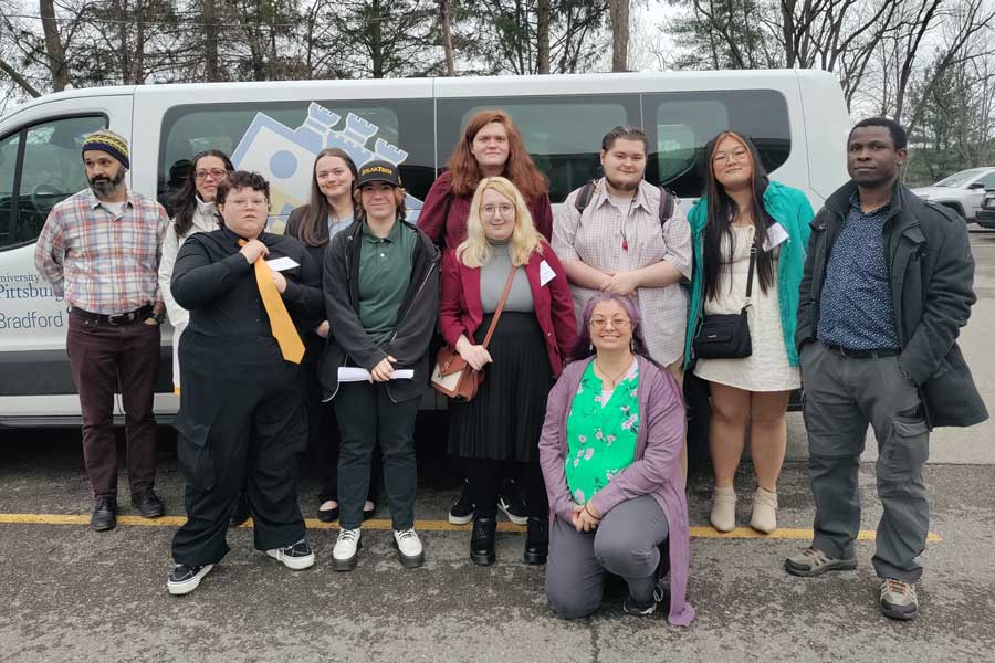 Students with faculty standing in front of a van while at Penn-York