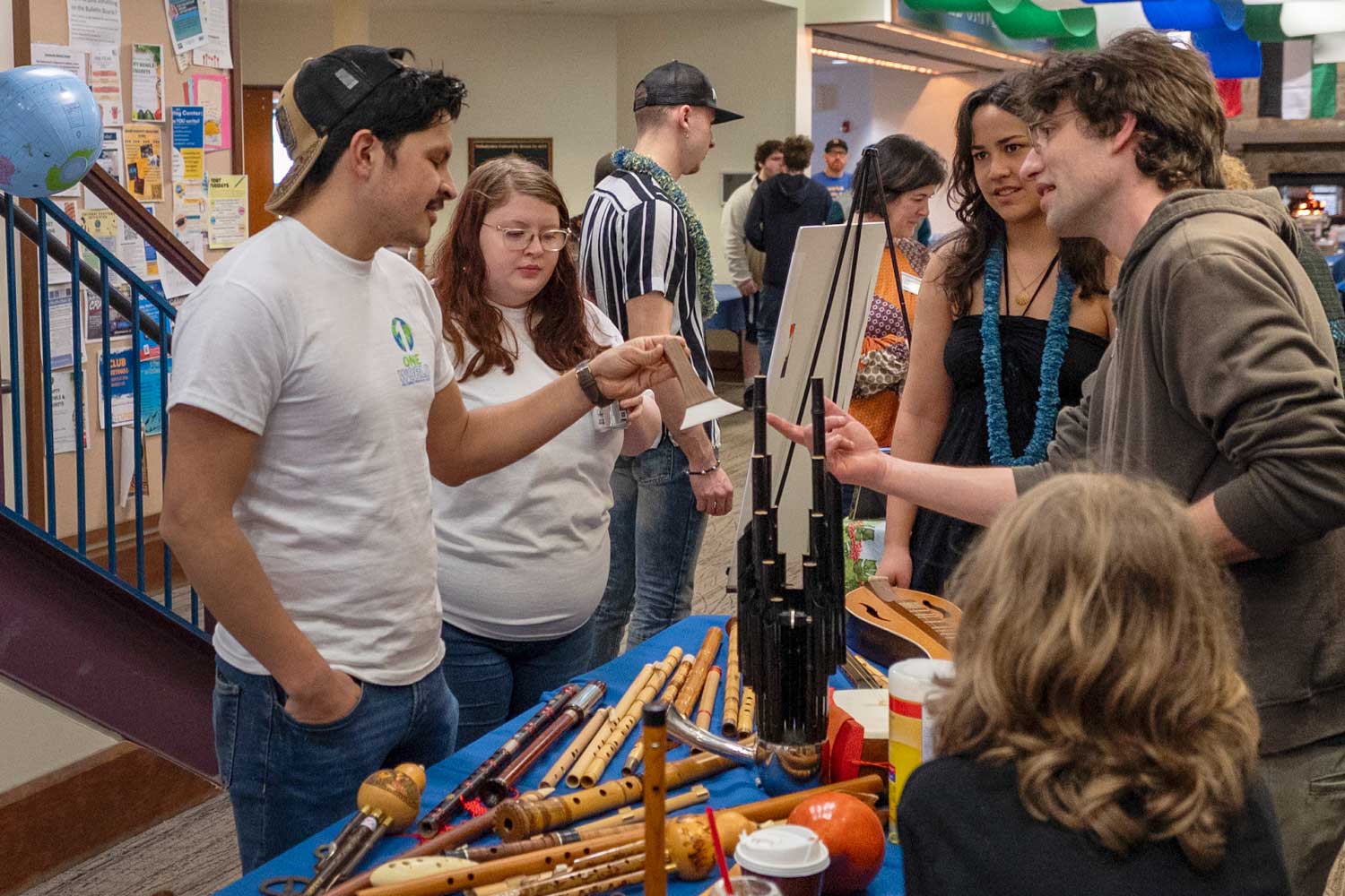 Students standing at a table with various musical instruments on it