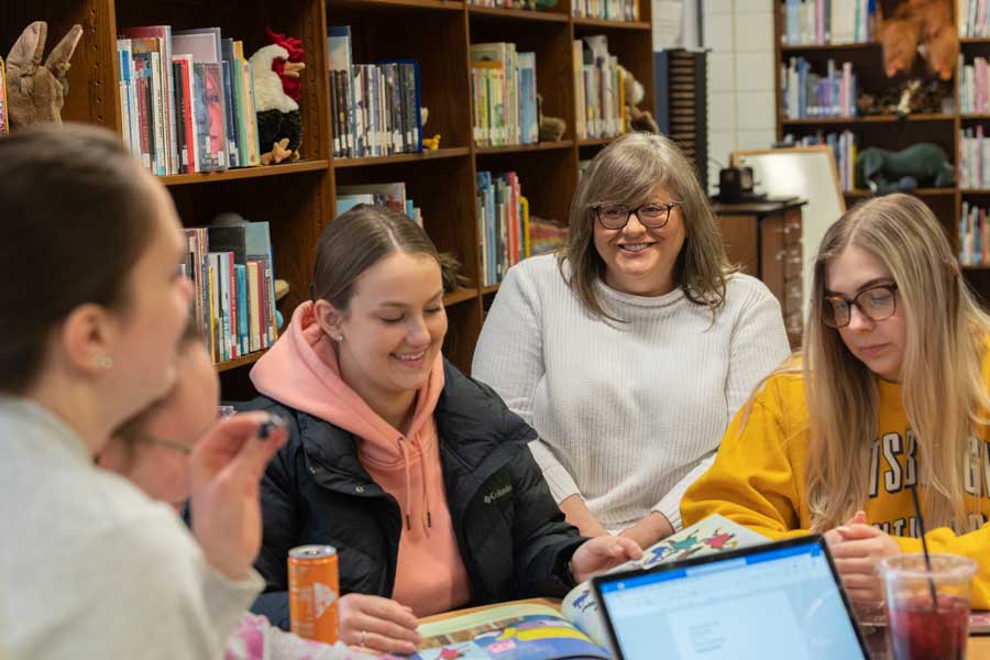 Dr. Patricia Lanzon with students in the library