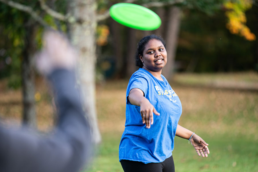 a student throwing a frisbee to a friend