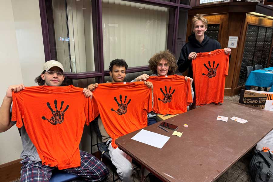 Lacrosse players holding orange t-shirts