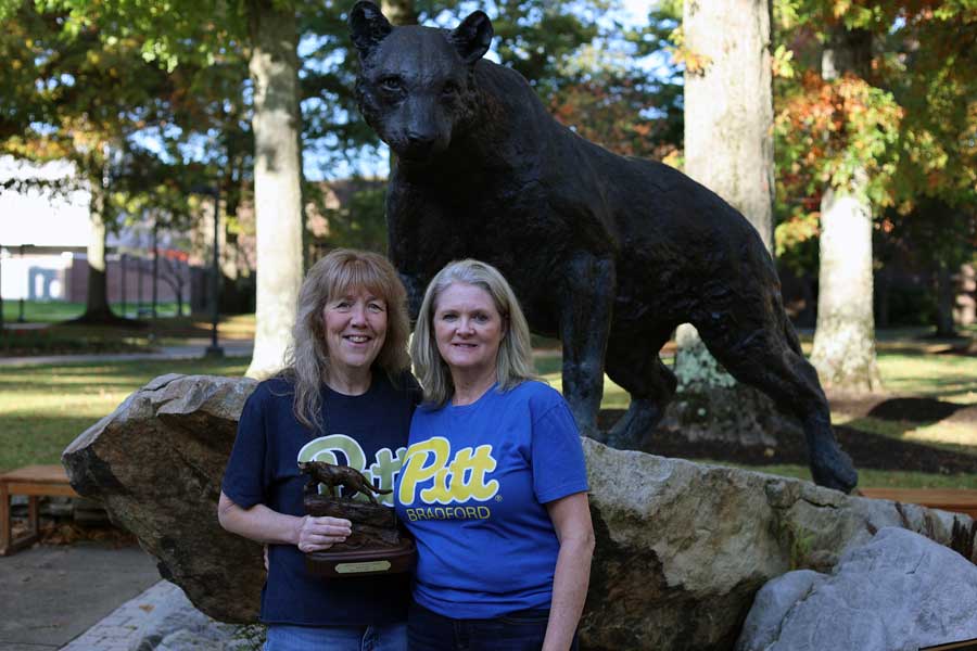 Kathy Moonan and Tammy Luciano in front of the panther statue