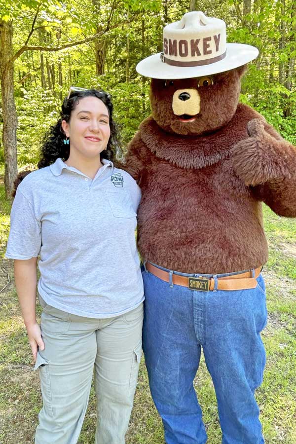 Sam standing with Smokey Bear