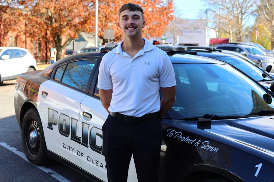 Joe standing in front of a police car