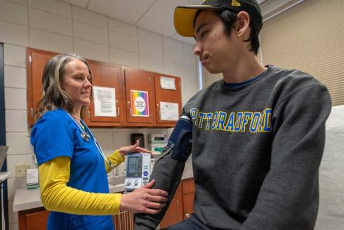 Nurse taking students temperature