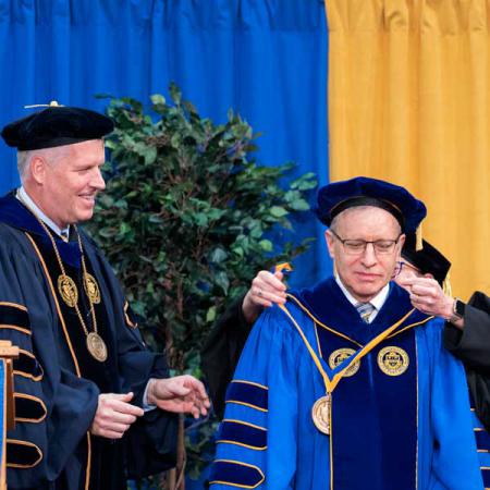  Richard T. Esch, president of the University of Pittsburgh’s Bradford and Titusville campuses, receives the presidential medal from Ann Cudd, University of Pittsburgh provost and senior vice chancellor, as Chancellor Patrick Gallagher looks on during the inauguration