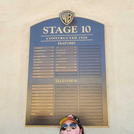 Louissa in front of a Stage 10 sign at Warner Brothers Studio