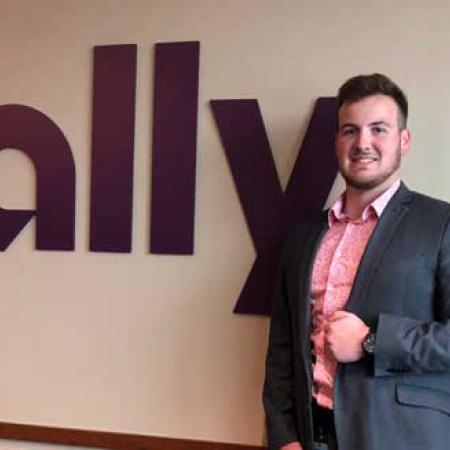 Mason Martell in front of the Ally company sign
